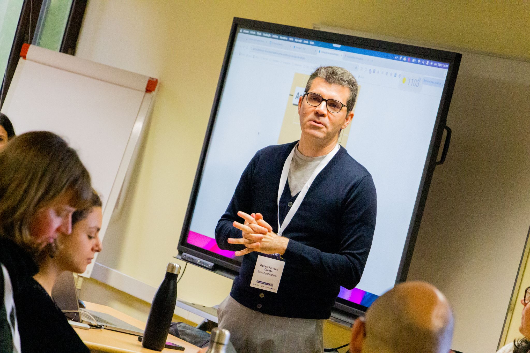 Orador na apresentação do seu workshop com o apoio de um ecrã interativo