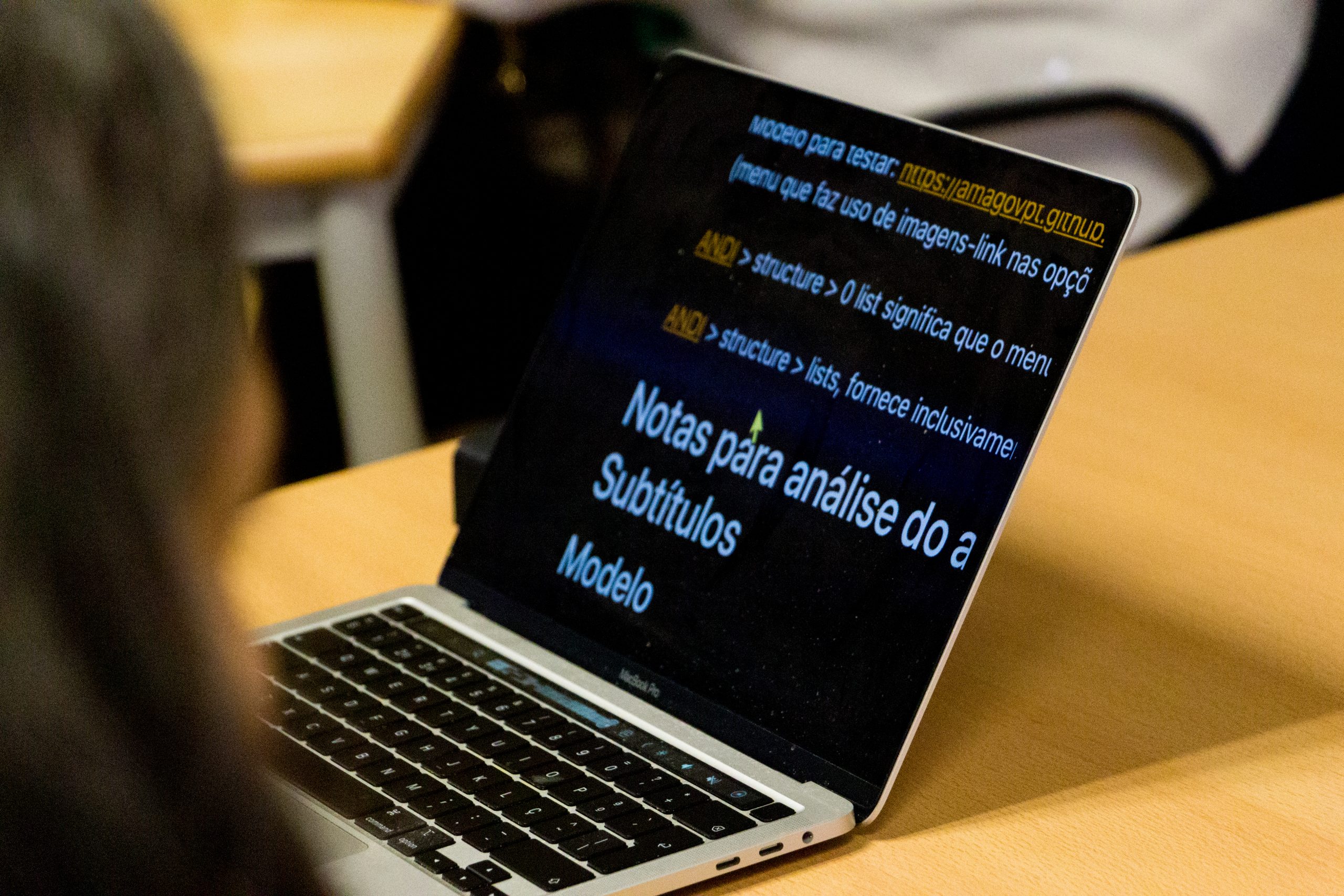 Ecrã de portátil com interface ampliada a mostrar notas sobre acessibilidade, com destaque para títulos e subtítulos, durante um workshop das Jornadas